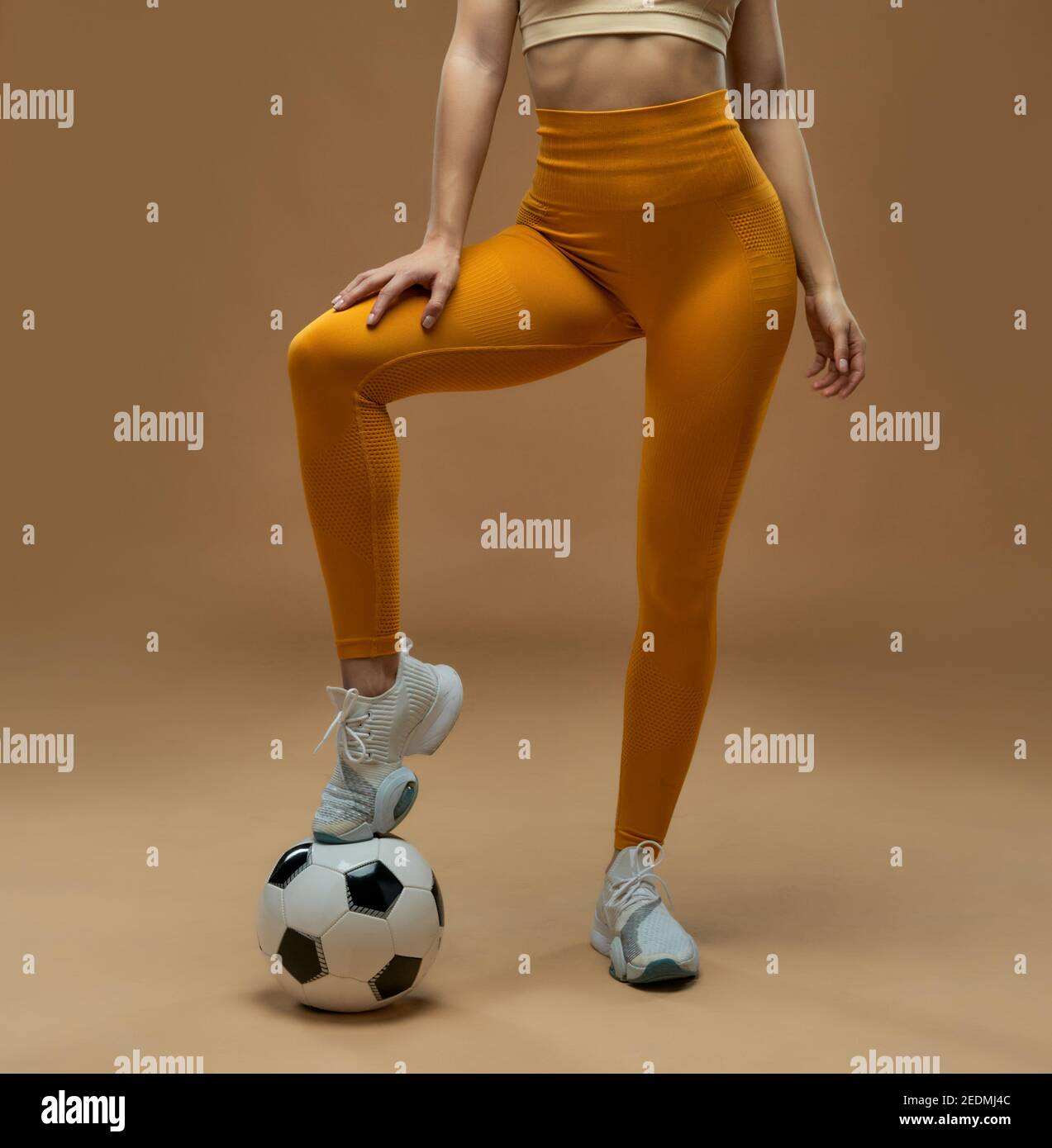 Female football player wearing sports leggings while posing with