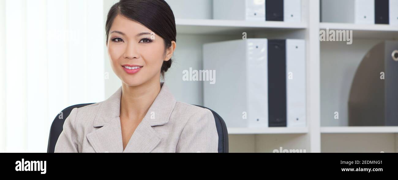 Panoramic portrait of a successful young Asian Chinese woman or business woman in office panorama web banner header Stock Photo