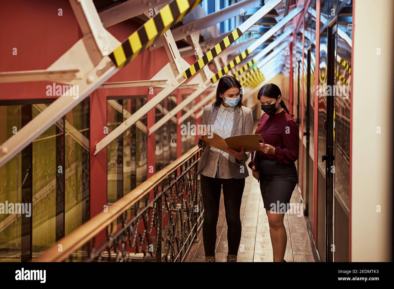 Pretty young designer showing her drawing to colleague Stock Photo - Alamy