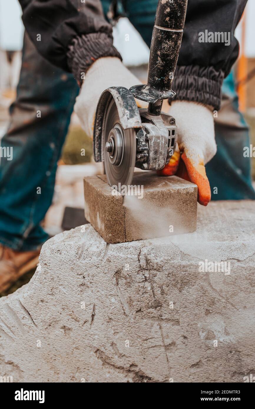 Sawing concrete stone with a diamond blade on an electric grinder - powerful stone cutter Stock Photo