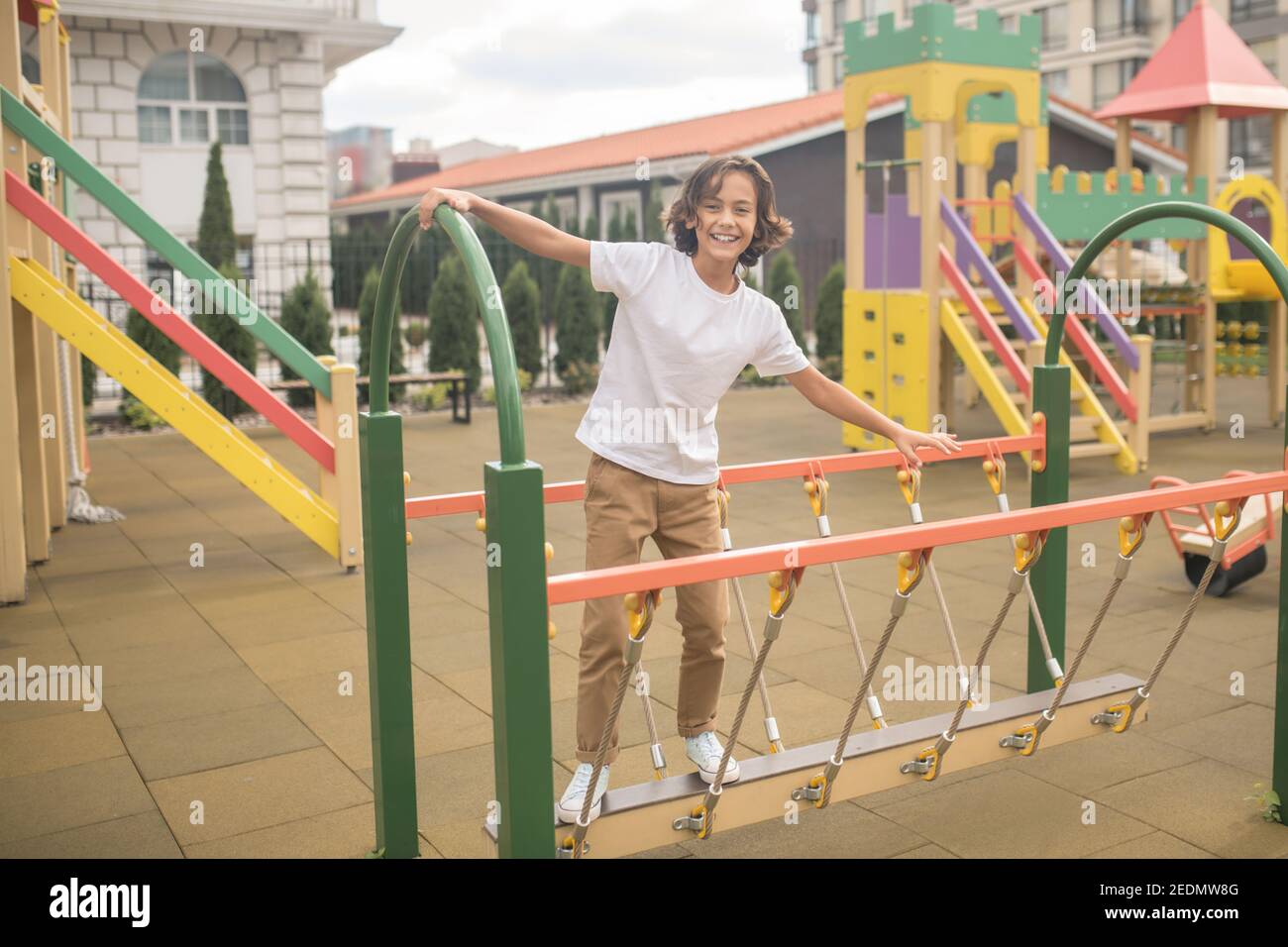 Cute boy in a white tshirt playing on a playground Stock Photo