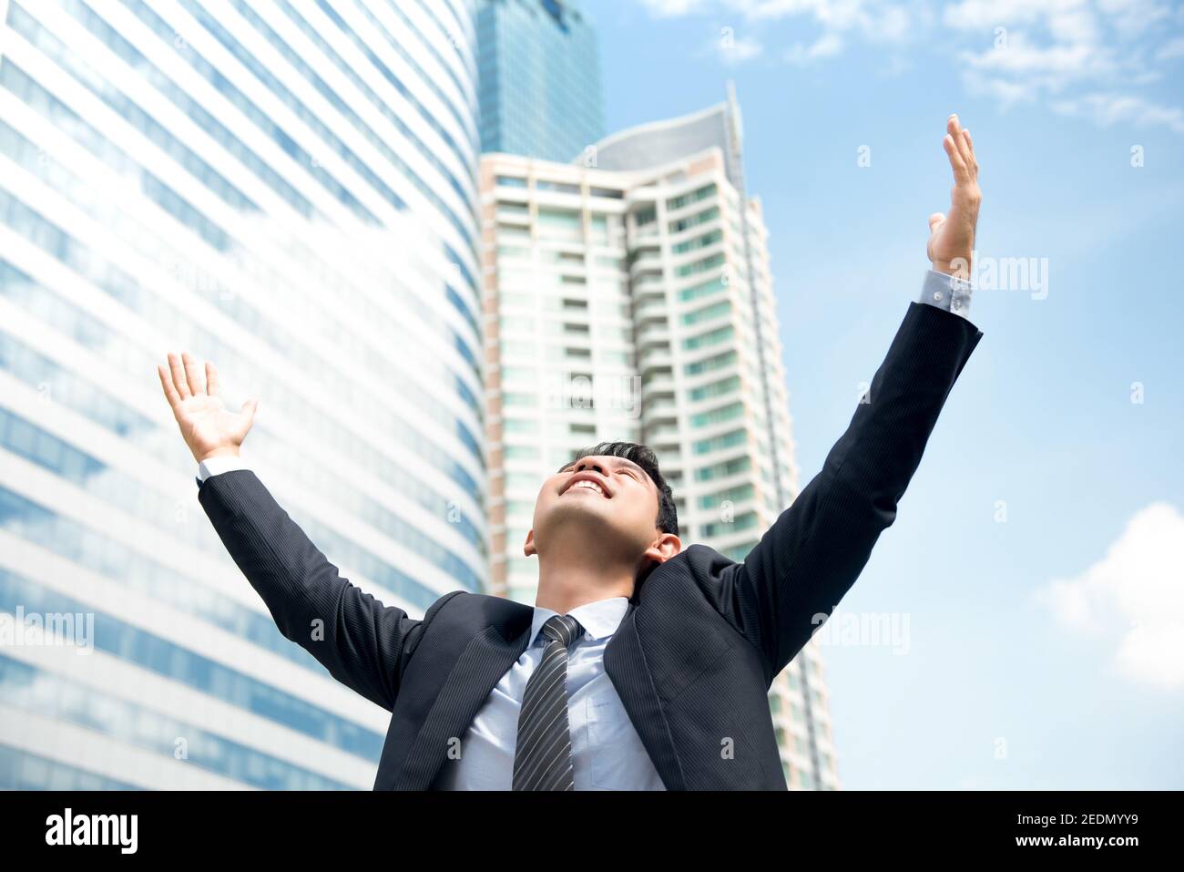 Happy businessman raising his arms in the air with opening palms ...