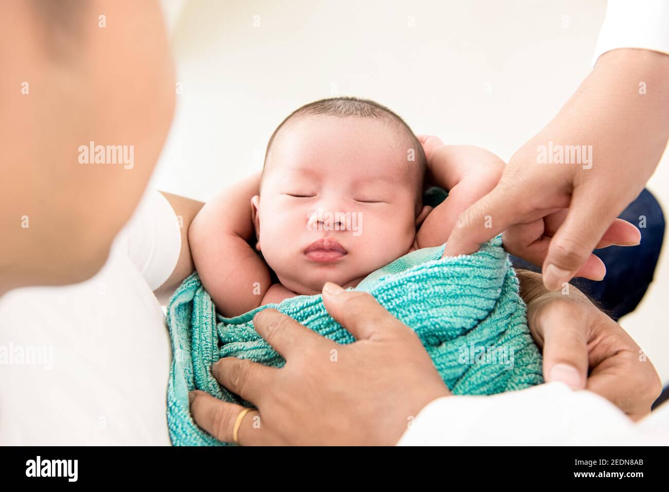 Adorable newborn little baby sleeping in the arms of father Stock Photo
