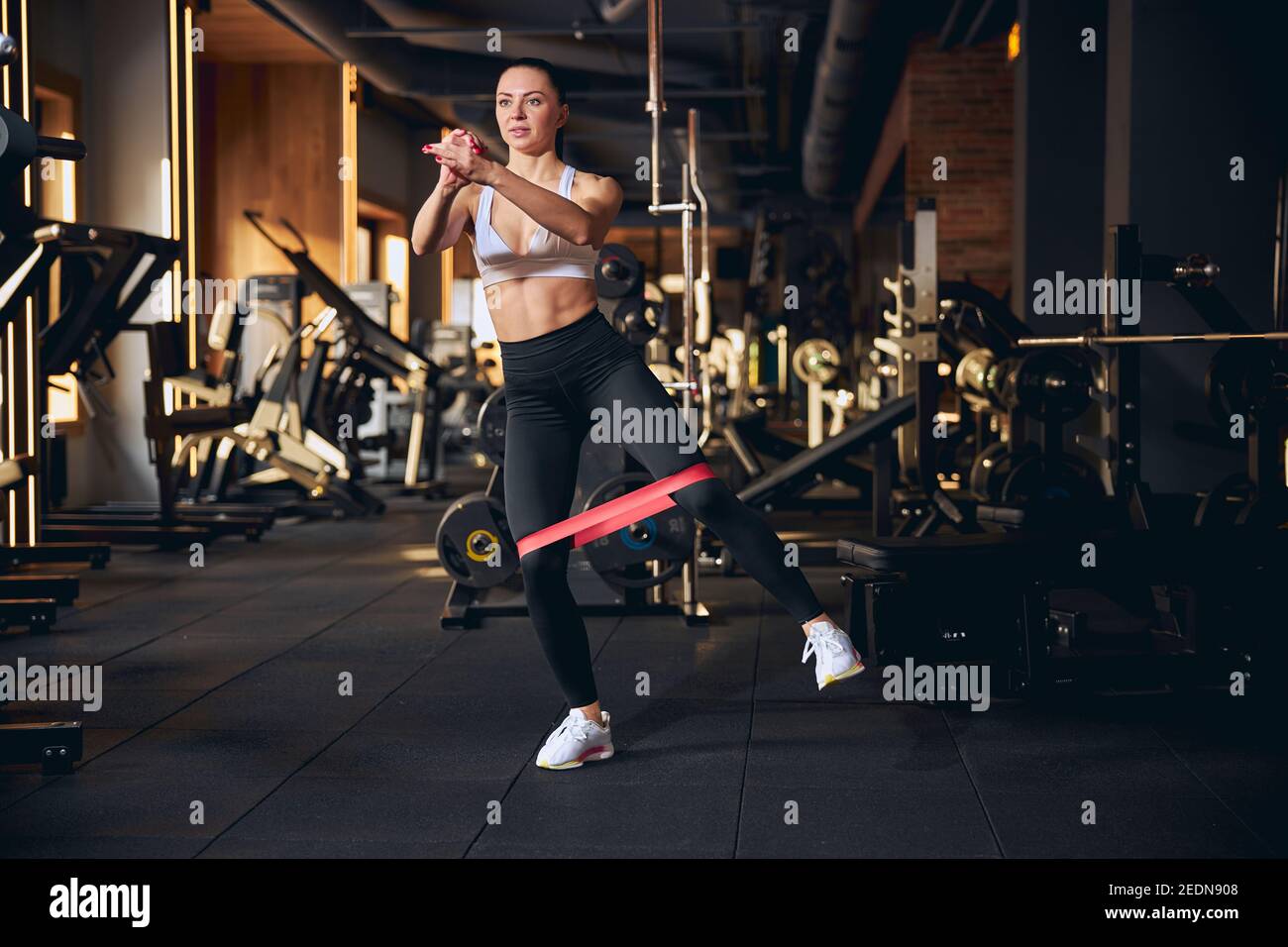 Motivated slim female training with outfit in gym Stock Photo - Alamy