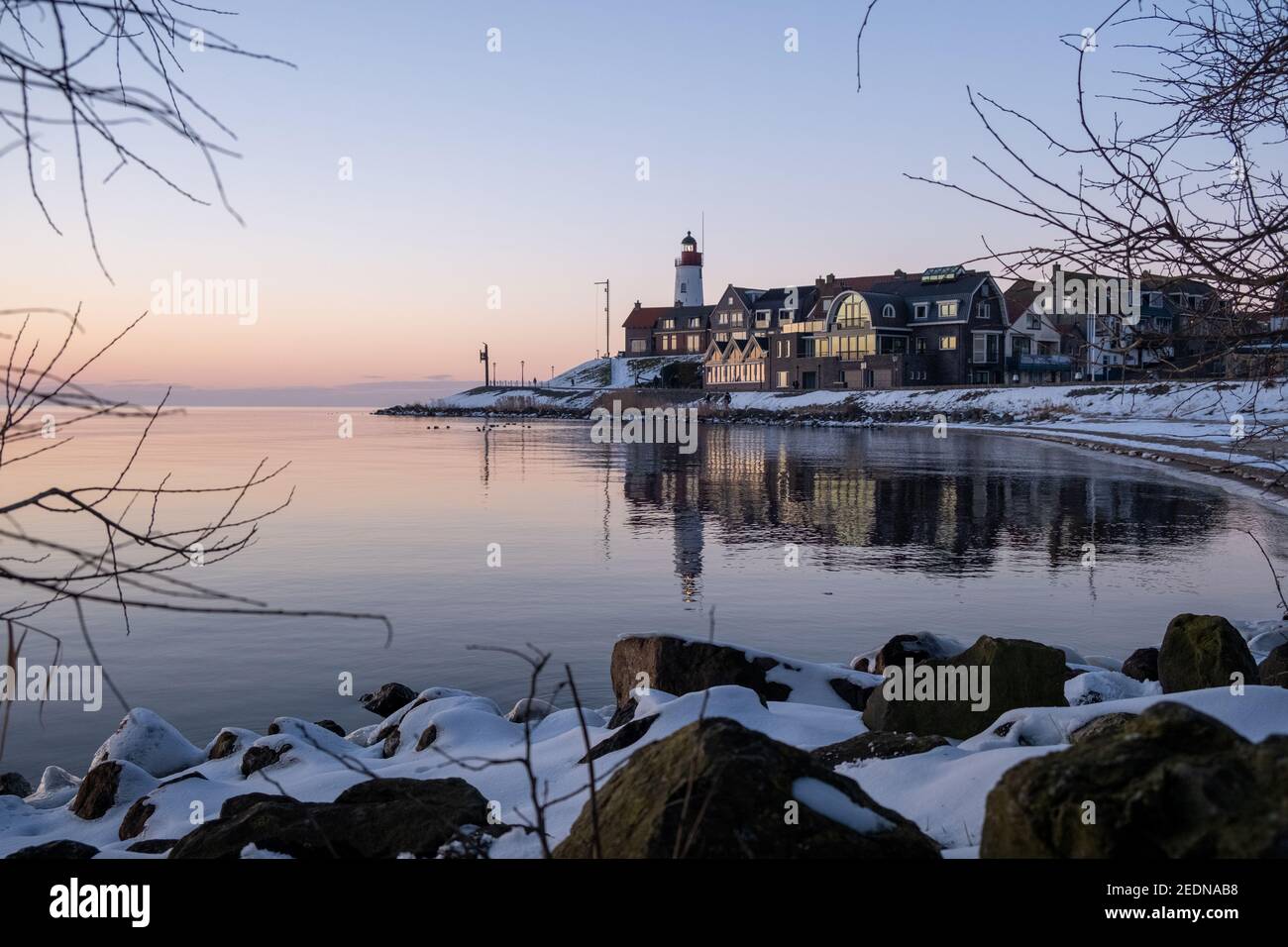 snow covered beach during wnter by Urk lighthouse in the Netherlands