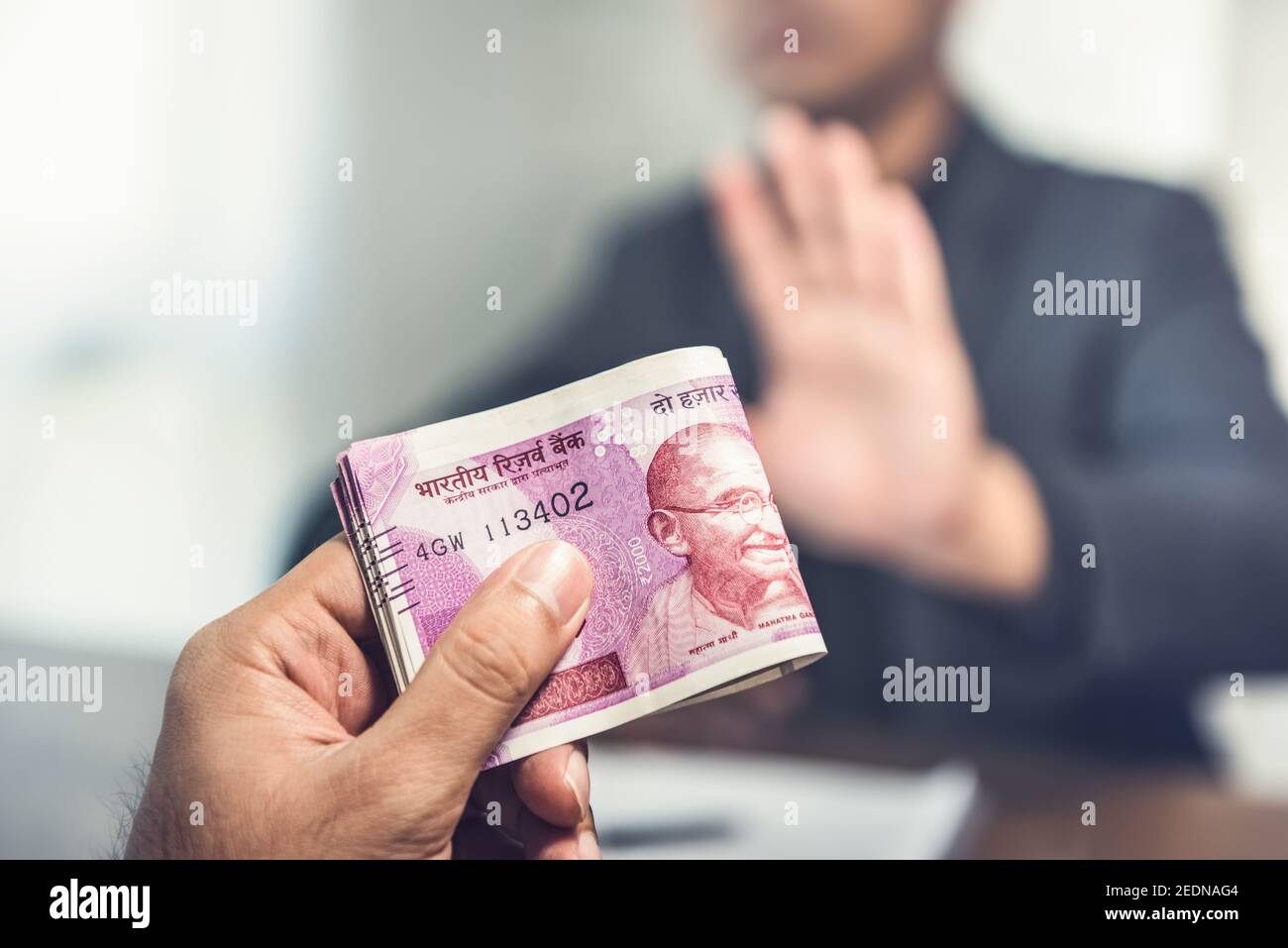 Businessman offering money in the form of Indian Rupee currency as a bribe Stock Photo