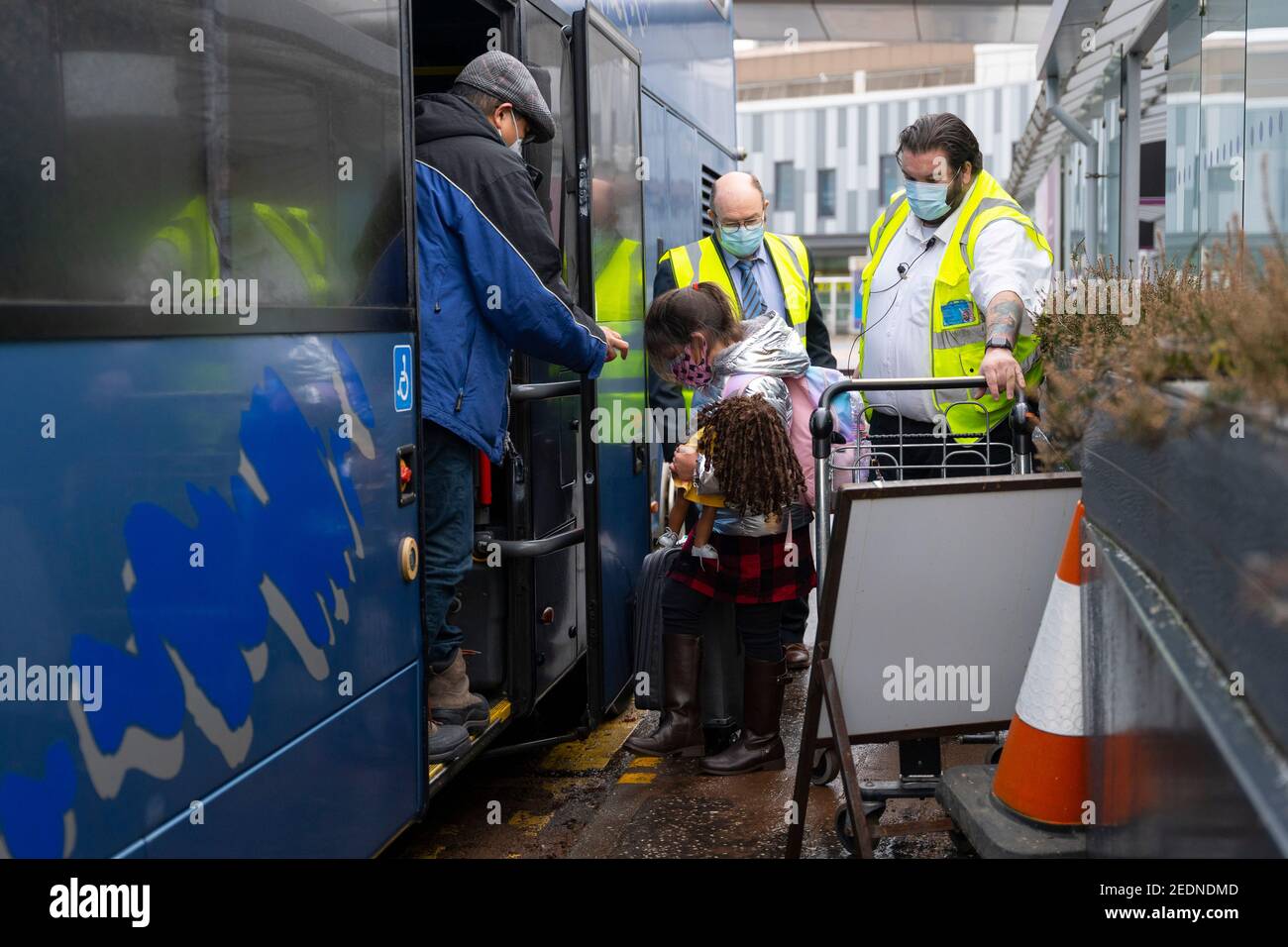 Edinburgh, Scotland, UK. 15 Feb 2021. From today Scottish Government requires all passengers from overseas arriving at Scottish airports to go into a mandatory quarantine in a hotel. Pic; First family who transited to Scotland via Dublin to go into quarantine arrives at Edinburgh airport and are escorted onto a bus that will take them to a guarded hotel for quarantine. Iain Masterton/Alamy Live news Stock Photo