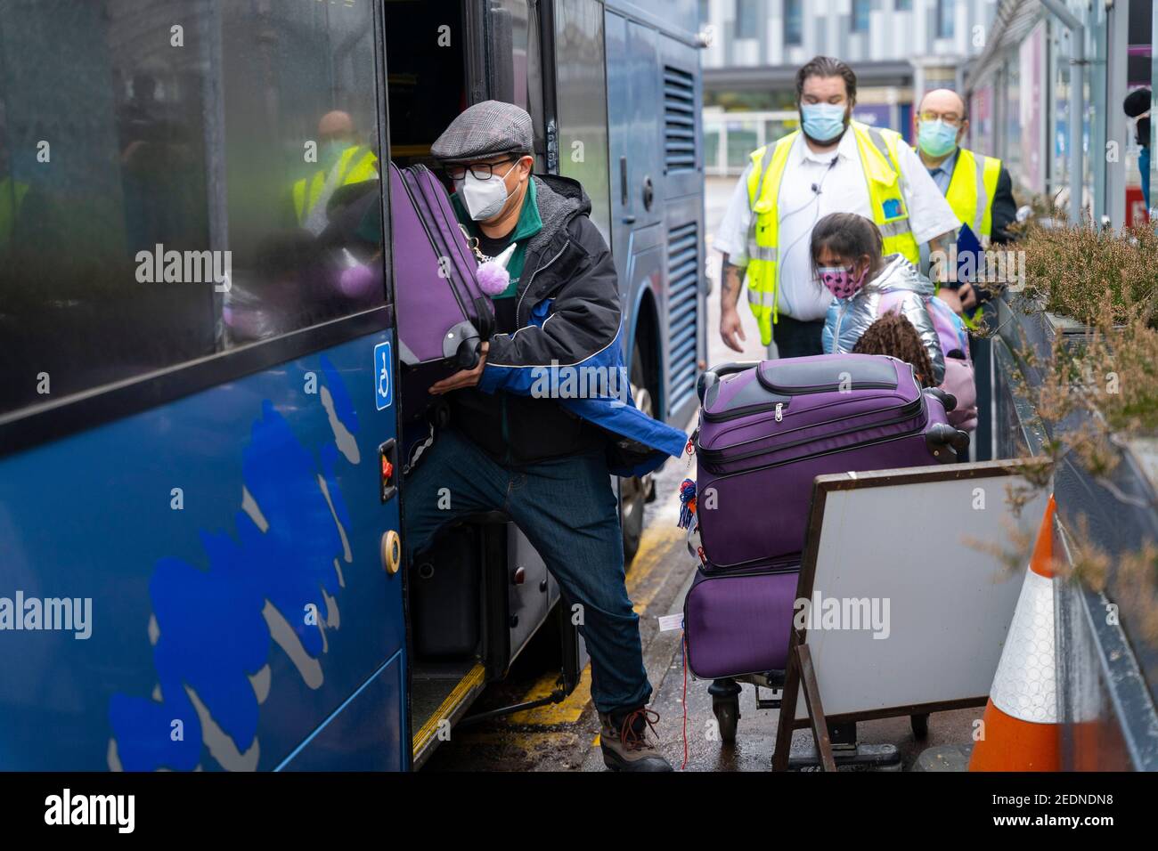 Edinburgh, Scotland, UK. 15 Feb 2021. From today Scottish Government requires all passengers from overseas arriving at Scottish airports to go into a mandatory quarantine in a hotel. Pic; First family who transited to Scotland via Dublin to go into quarantine arrives at Edinburgh airport and are escorted onto a bus that will take them to a guarded hotel for quarantine. Iain Masterton/Alamy Live news Stock Photo