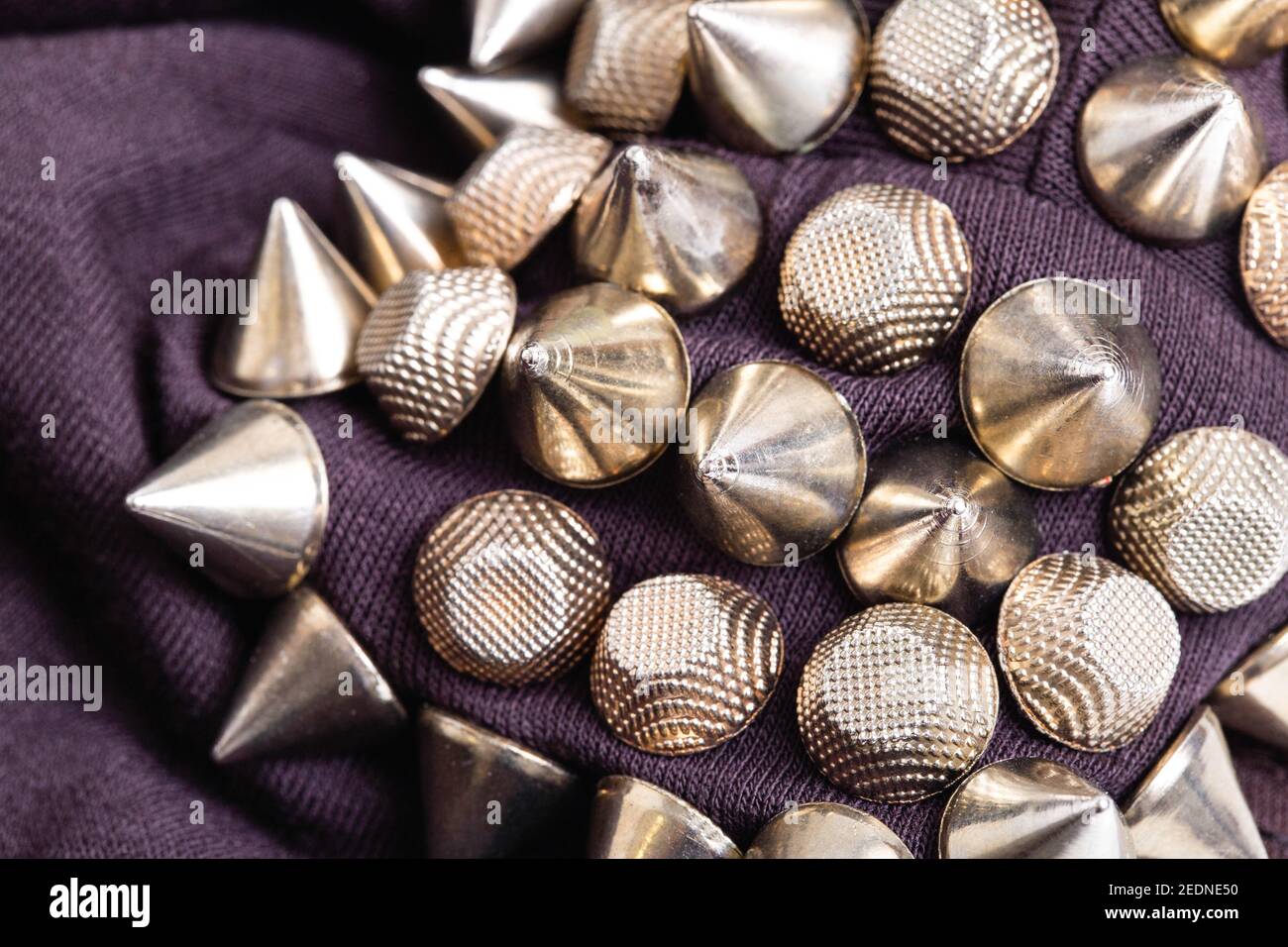 Metallic triangles cones on the shoulder of the garment. Steampunk clothing concept, close-up, stylish Stock Photo