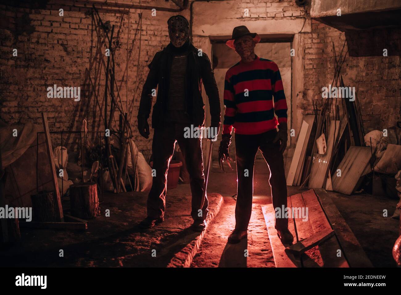 Cosplayers stand in old basement in image of Freddy Krueger and Jason Voorhees from Nightmare on Elm Street film. Stock Photo