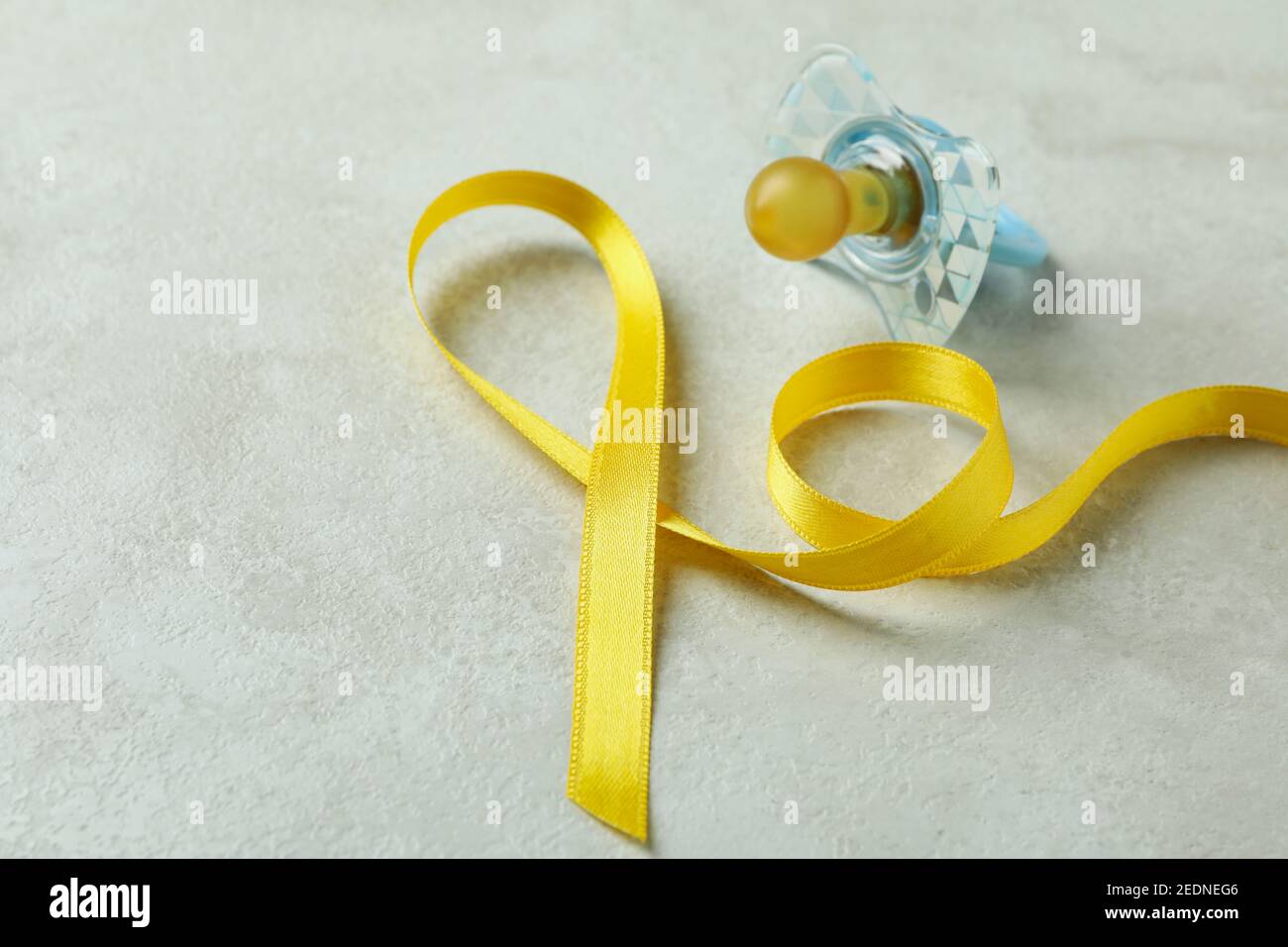 Pacifier and awareness ribbon on white textured background Stock Photo ...