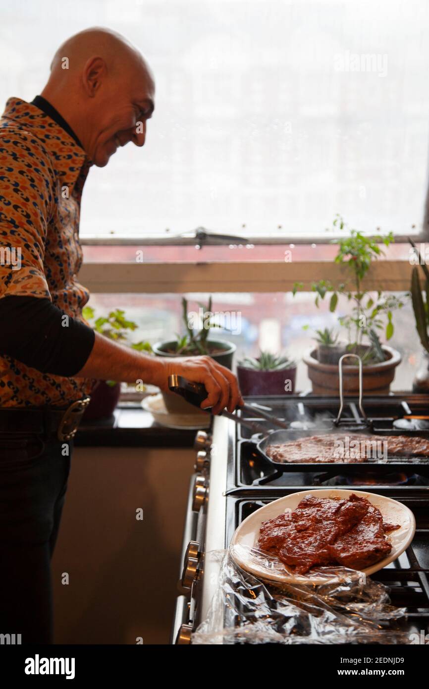 Man Grilling Meat on Stove Stock Photo