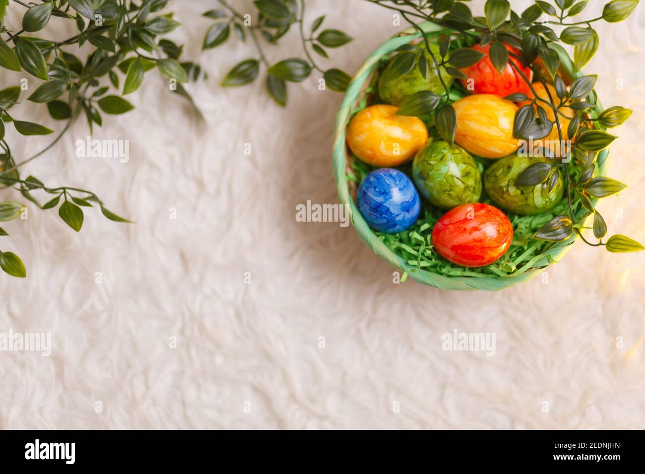Easter card. Flat lay composition with easter eggs in a basket on white ...