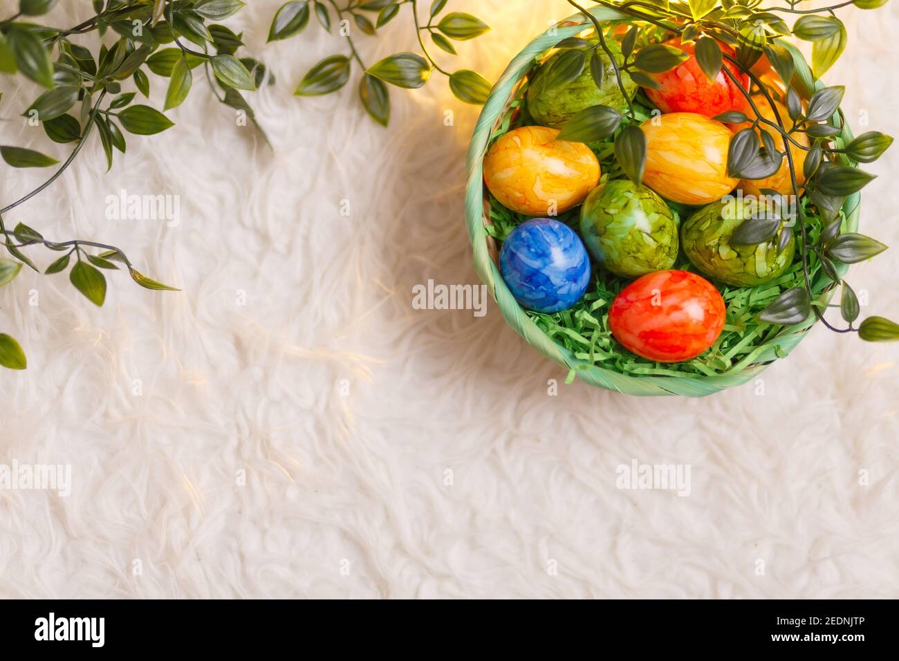 Easter card. Flat lay composition with easter eggs in a basket on white ...