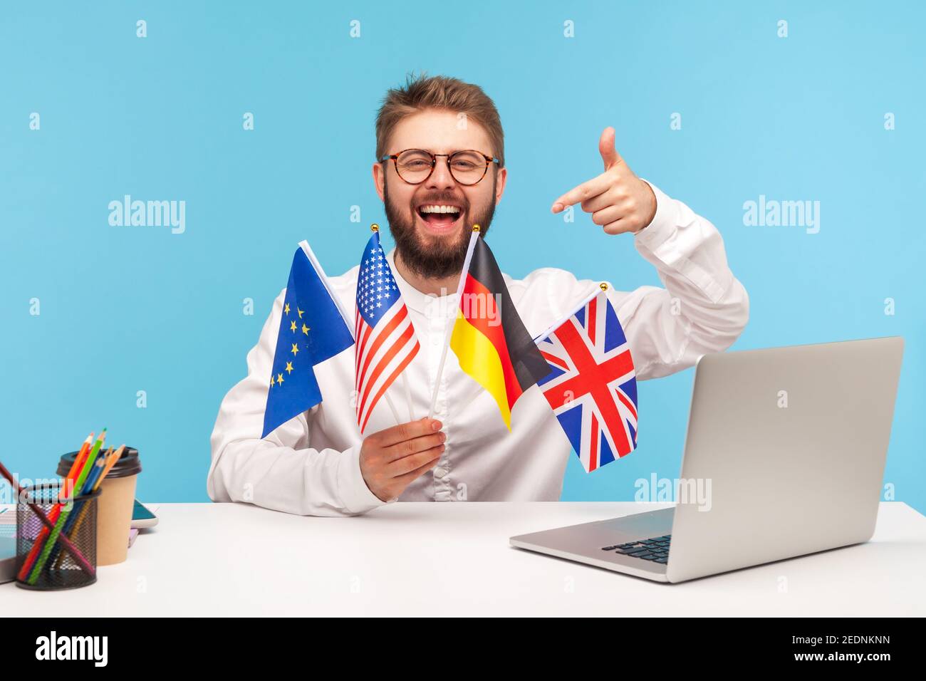 Positive smiling man in eyeglasses holding flags of usa, german, great britain and europe countries, bragging with knowing of many languages, polyglot Stock Photo