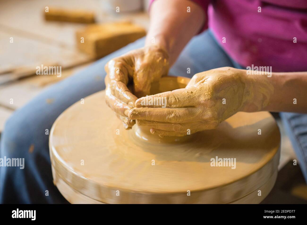 female potter shaping a vase from clay in a pottery workshop , Germany Stock Photo