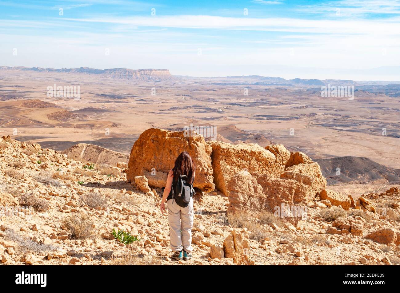 A group of hikers hiking in Makhtesh Ramon a geological feature of Israel's Negev desert. Located at the peak of Mount Negev, the world's largest 'ero Stock Photo