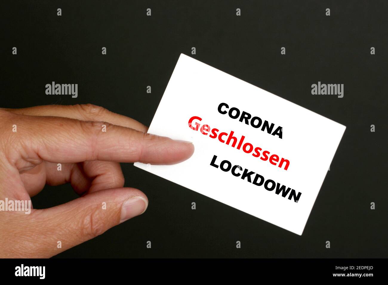 hand with visiting card lettering Corona-Lockdown, Germany Stock Photo