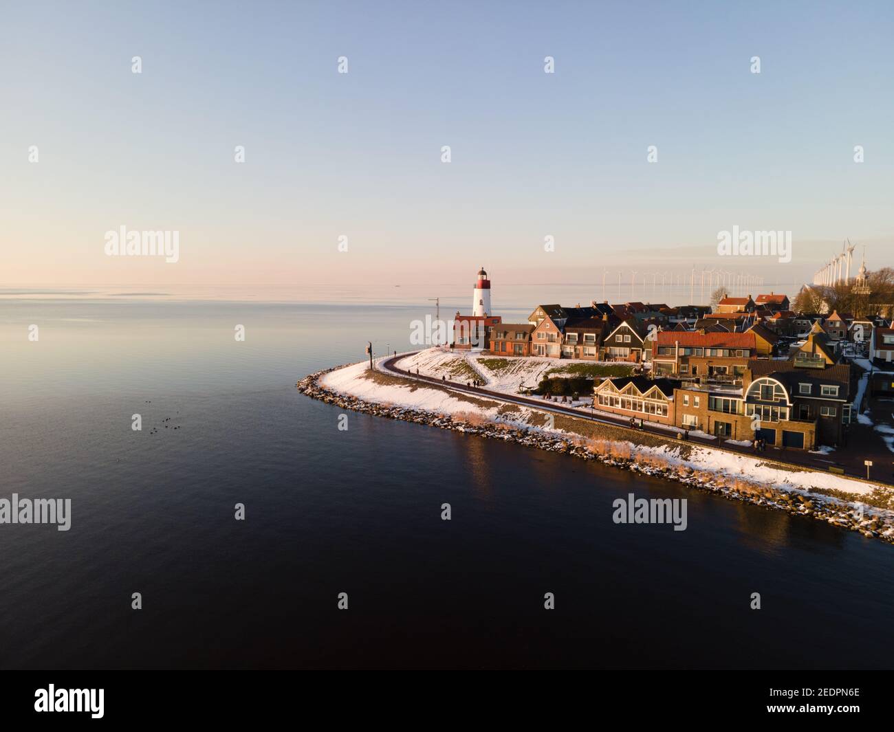 snow covered beach during wnter by Urk lighthouse in the Netherlands