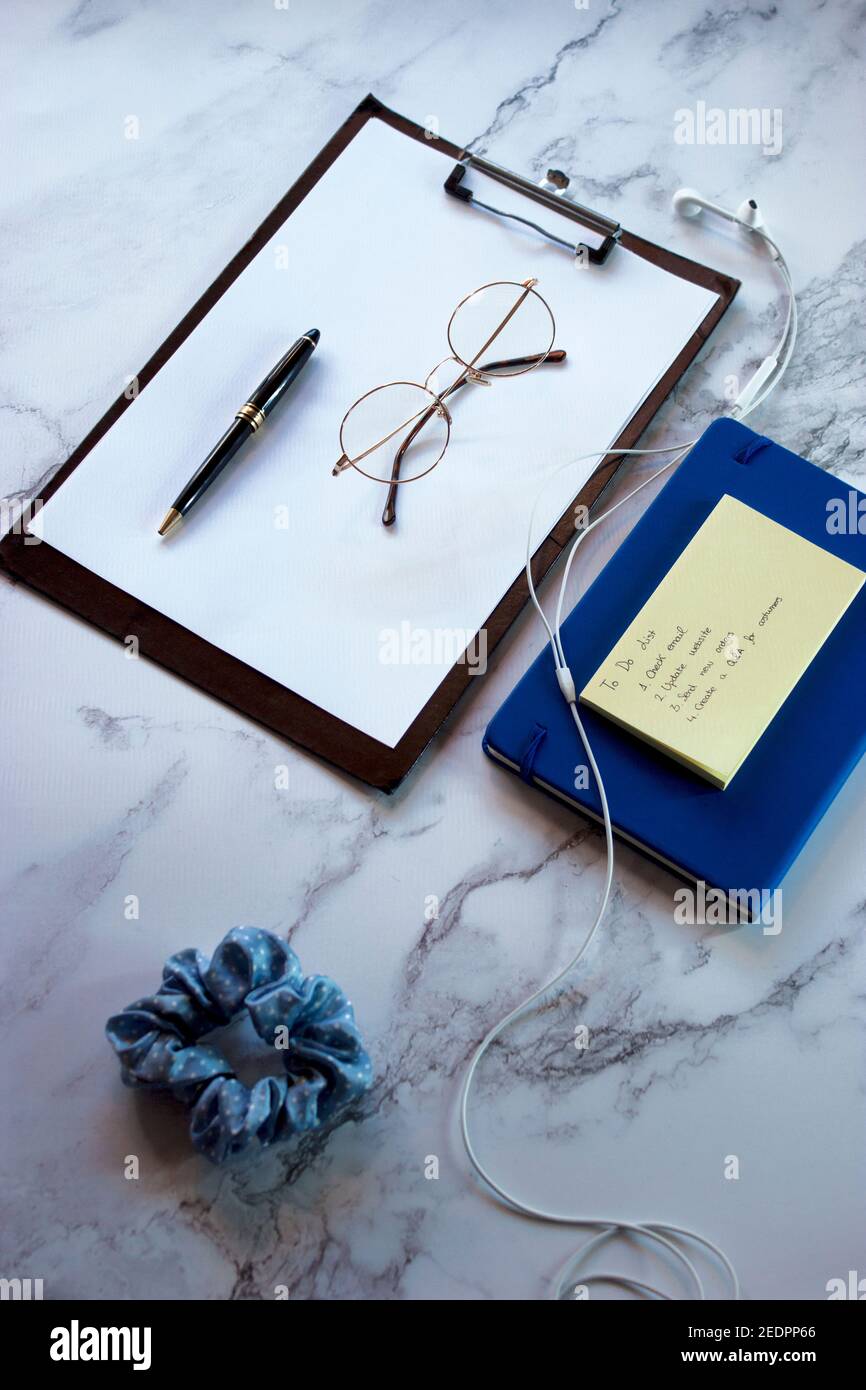 Top view marble desk notepad with to-do list, weekly agenda for planning and organizing the work day. Small Business Owner Concept 2021 Stock Photo