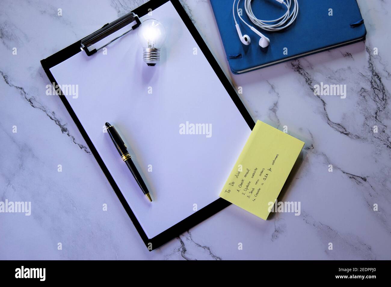 Top view marble desk notepad with to-do list, headphones, personal agenda, blank pages and pen to write on blank pages. Small Business Owner 2021. Stock Photo