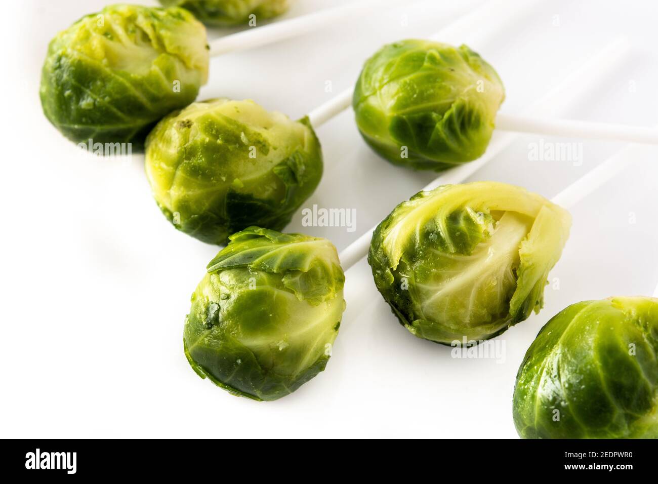 Set of brussel sprouts with lollipop sticks on white background Stock