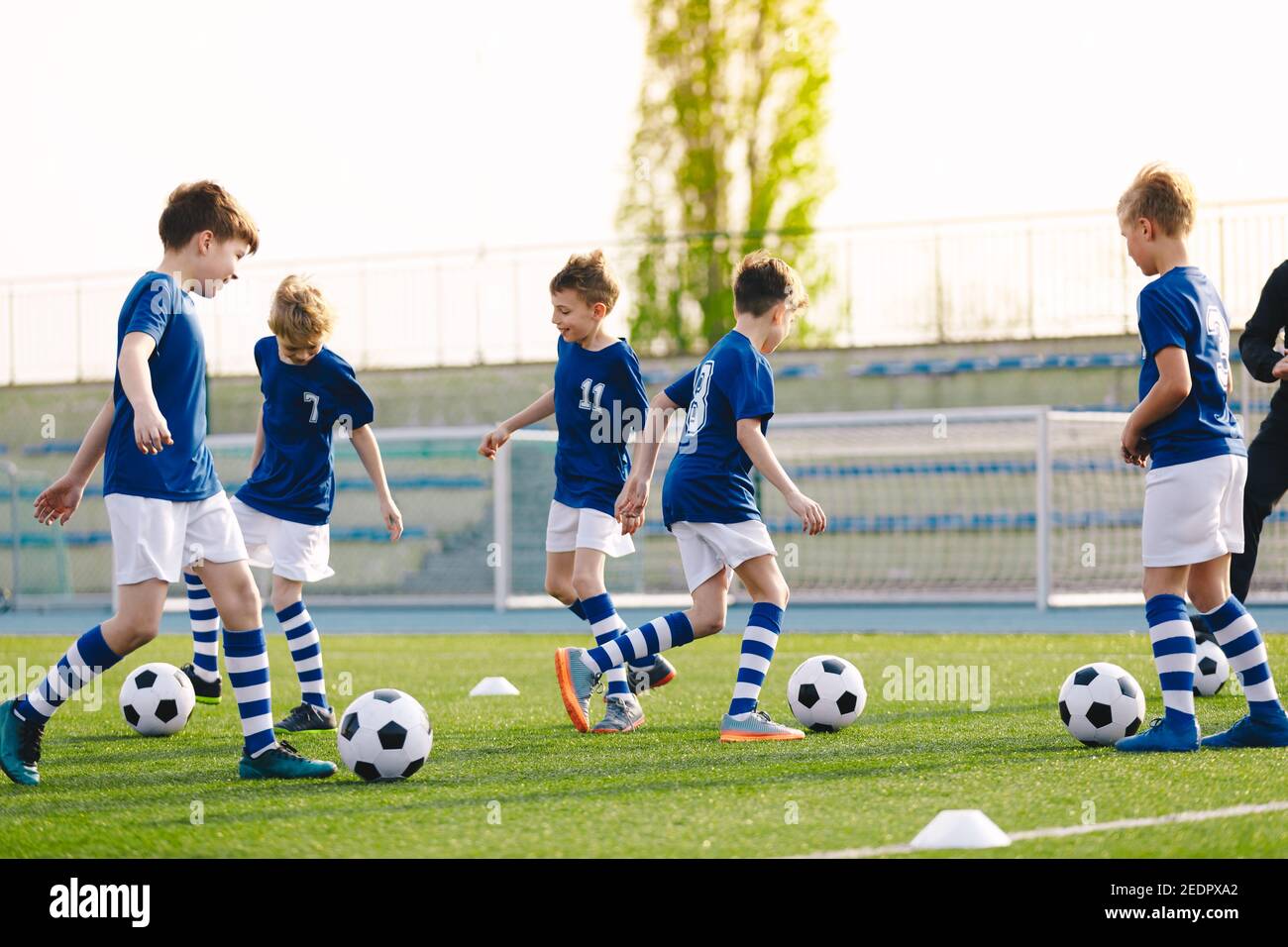 Football Education for Kids. Physical Education for Children. Young Coach With Kids in Soccer Team on Training Unit. Youth Team Coach Training School Stock Photo