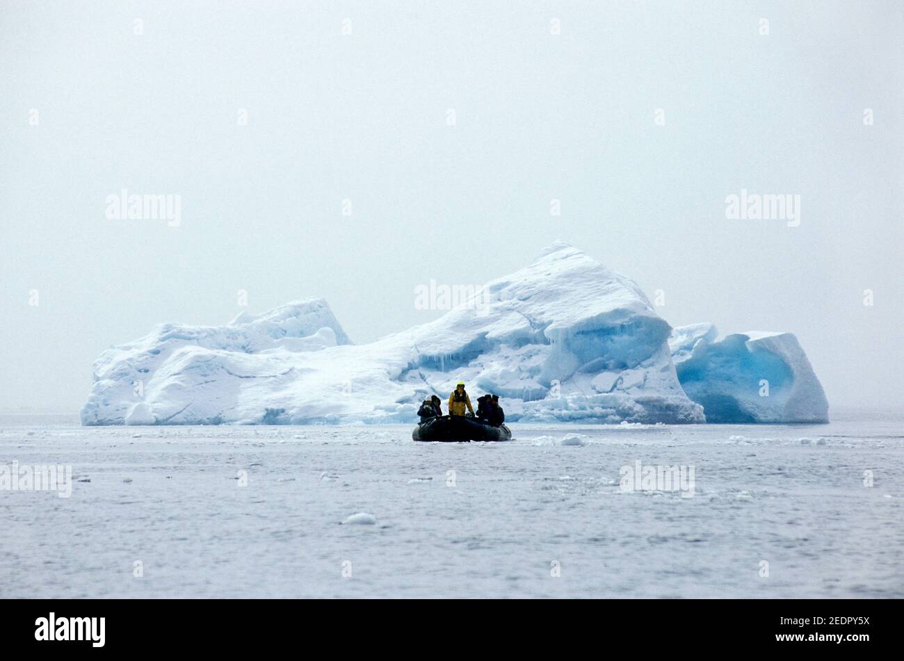 A zodiac with tourists is returning after checking out an iceberg on Antarctica Stock Photo