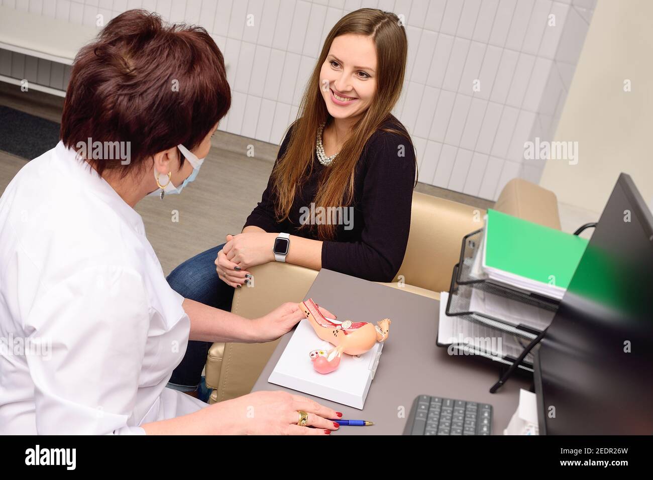a young woman is being consulted by an obstetrician-gynecologist. Stock Photo