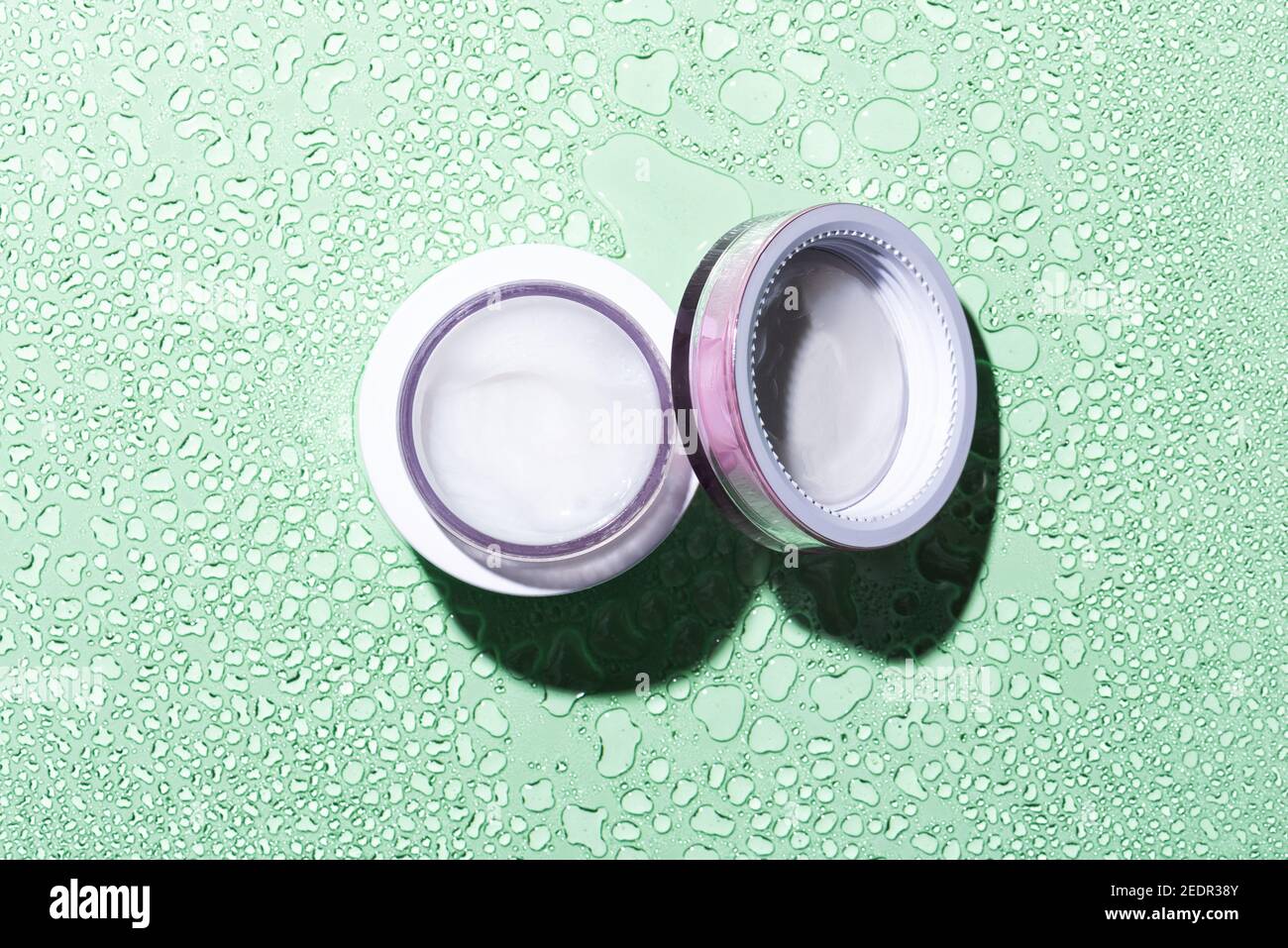 Moisturizing beauty face cream jar on green background Stock Photo