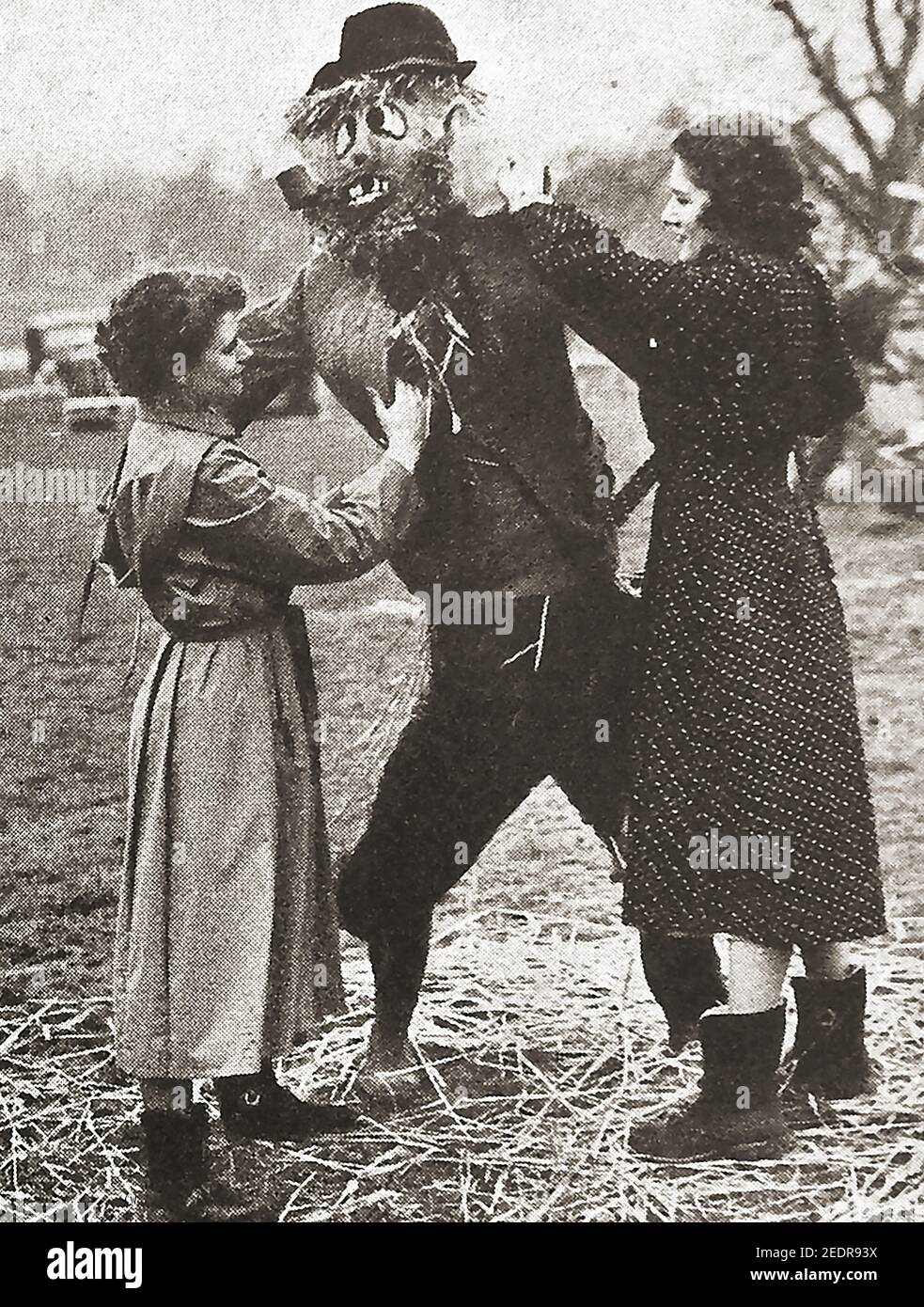 Circa 1930's  - A very early printed photograph of British female Young Farmers Club members building a scarecrow. The first Young Farmers’ Club opened in 1921 in Hemyock, Devon, where the United Dairies milk factory gave local farmers children the chance to rear calfs for prizes. By the end of WWII clubs had spread throughout Britain and the colonies with a wide range of activities for members including beauty contests. The national office moved from London to Stoneleigh Park, Warwickshire, in 1968. The Foot & Mouth outbreak in 2001 set back the organisation but it is now is bouncing back Stock Photo