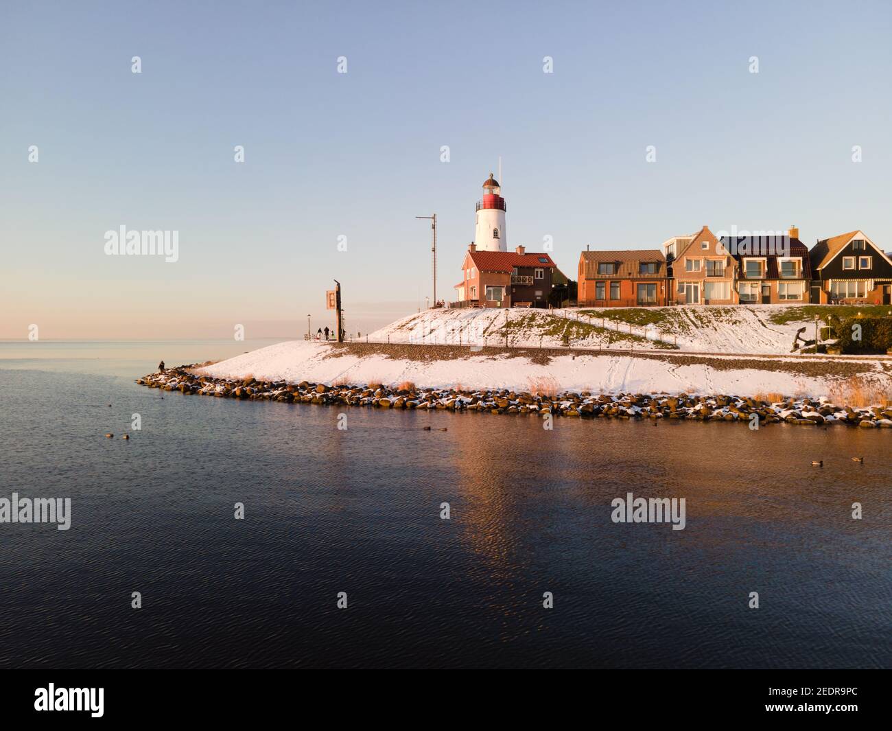 snow covered beach during wnter by Urk lighthouse in the Netherlands