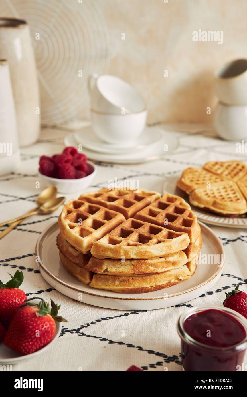 Delicious waffles with vanilla ice cream, strawberries and raspberries on a breakfast table Stock Photo