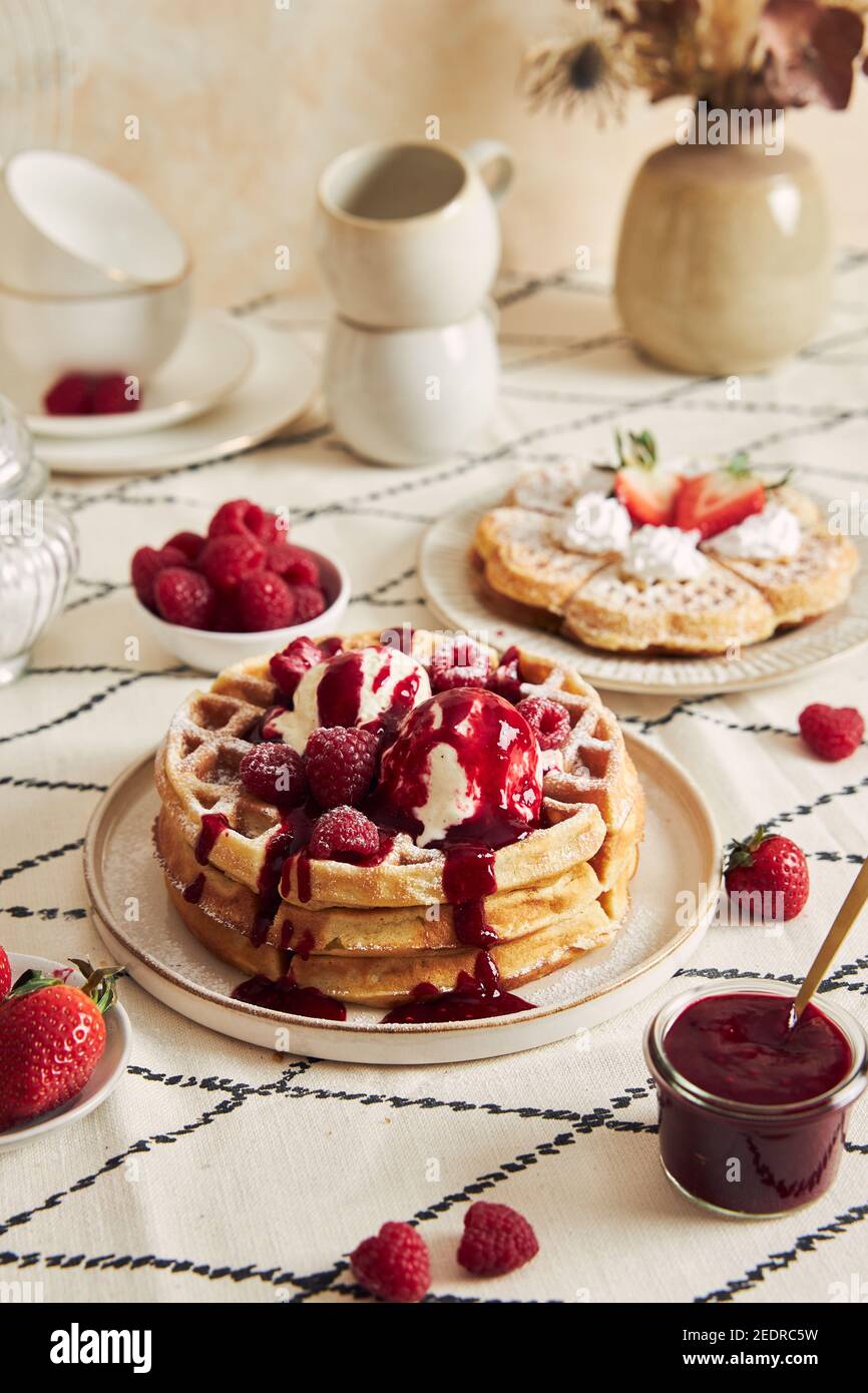 Delicious waffles with vanilla ice cream, strawberries and raspberries on a breakfast table Stock Photo