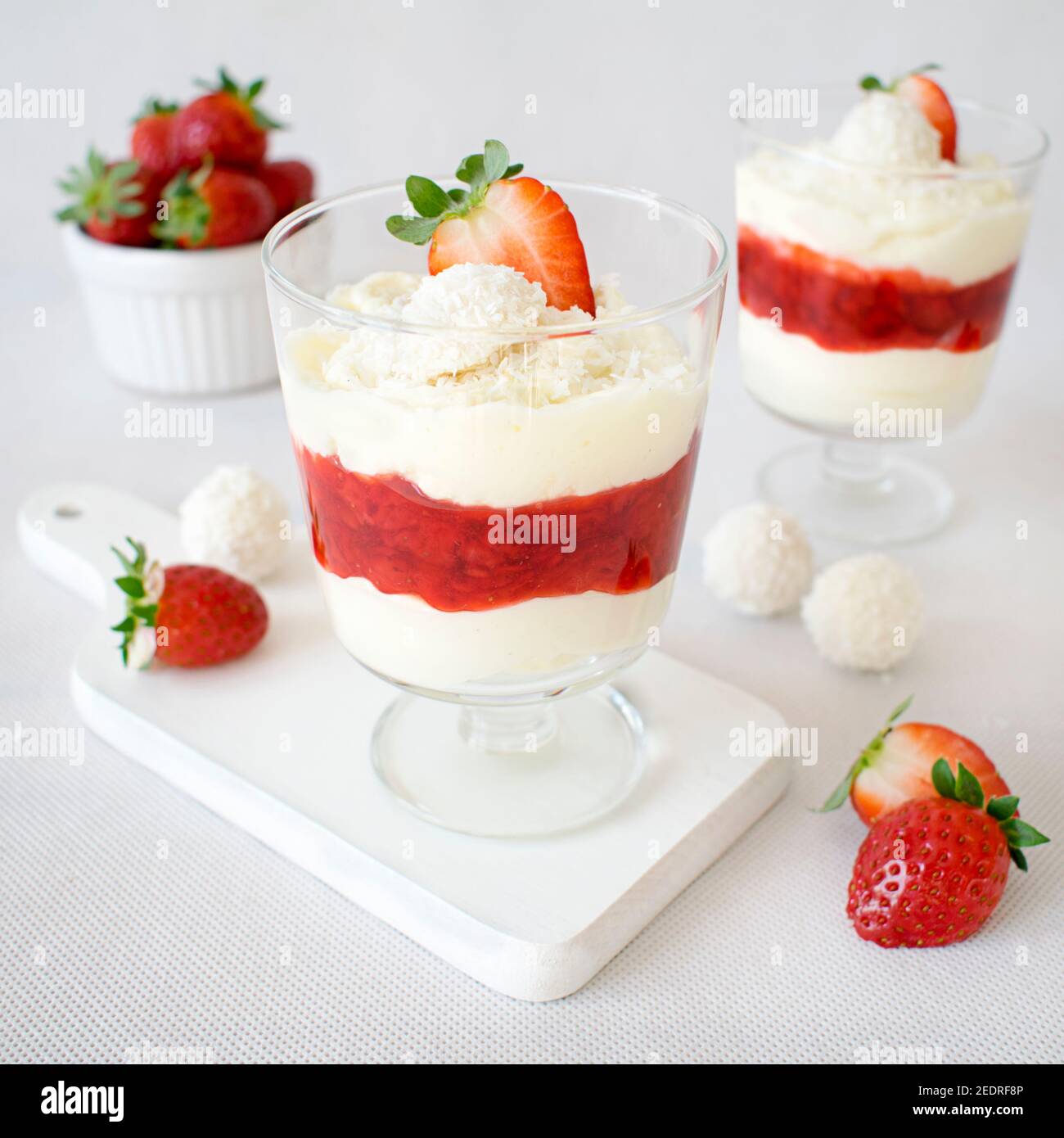 Coconut dessert with strawberry mousse. Fluffy cream with Raffaello balls, white chocolate and fresh strawberries. Stock Photo