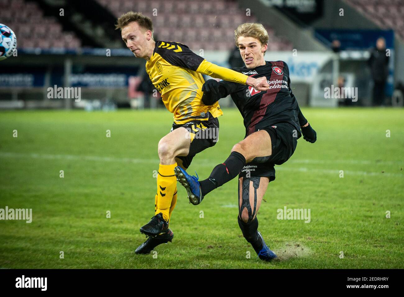 Herning, Denmark. 14th, February 2021. Soren Reese (5) of AC Horsens and Gustav Isaksen of Midtjylland seen during the 3F Superliga match between FC Midtjylland and AC Horsens at MCH Arena
