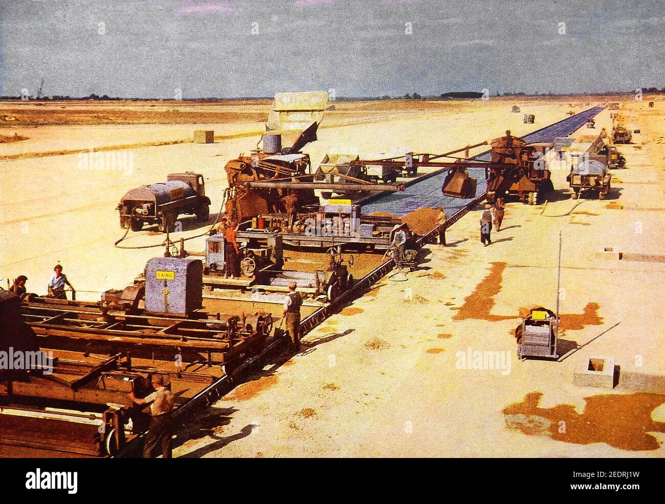 CONCRETE -An early colour photo from a brochure showing Pavers, Spreaders and  Finishers building what is believed to be Bedford Aerodrome, an airfield in Bedfordshire, England, The word LAING ( a construction firm ) can be seen on the machinery. Stock Photo
