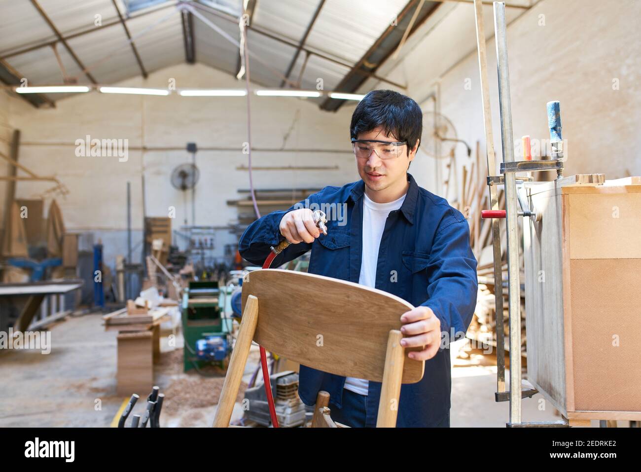 Craftsman apprentice repairing table in making Stock