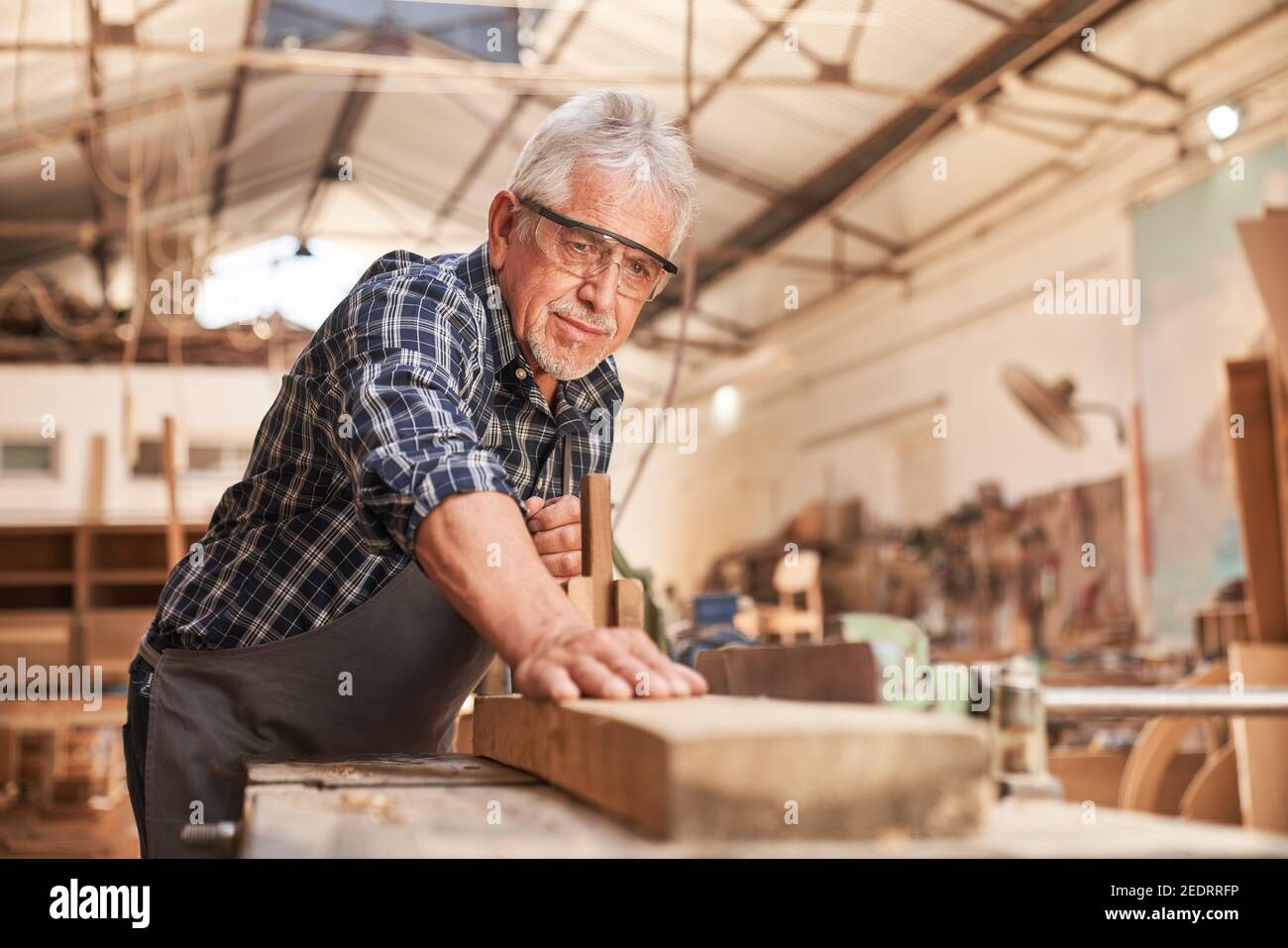 Craftsmen as carpenter master planing wood in the joinery or joinery Stock Photo