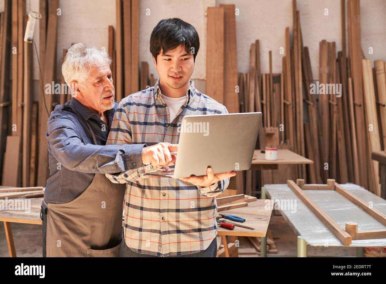 Senior craftsman and web designer using computer during website development Stock Photo