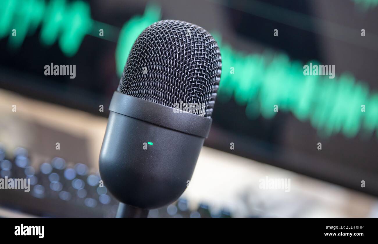 Tlted condenser mic, blur console and turquoise waveform background. Sound recording concept. Microphone for live audio, music, speech, concert, perfo Stock Photo