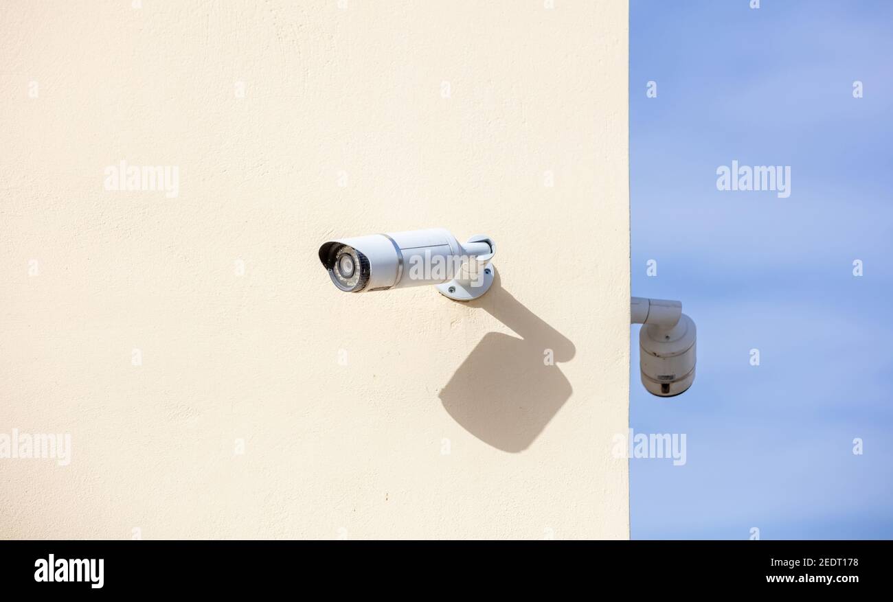 CCTV Cameras, Security system. Surveillance cams on painted wall, bkue sky background, copy space Stock Photo