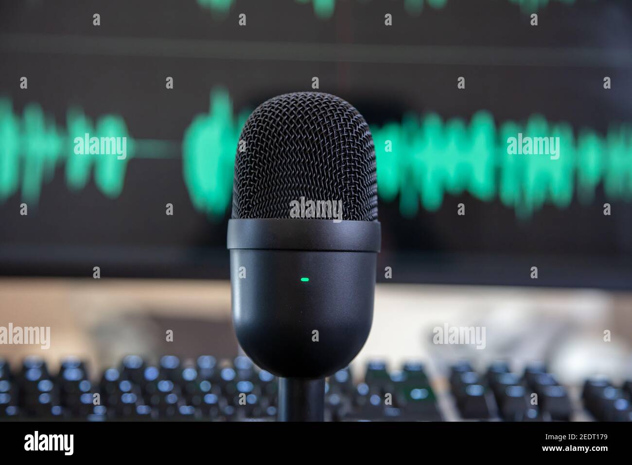 Sound recording concept. Black metallic condenser microphone, blur console and turquoise waveform background. Mike for live audio, music, speech, conc Stock Photo