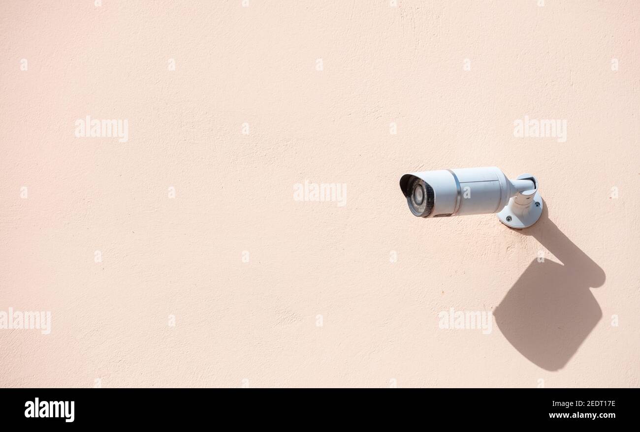 Security Camera CCTV. Surveillance cam isolated on painted wall background, copy space Stock Photo