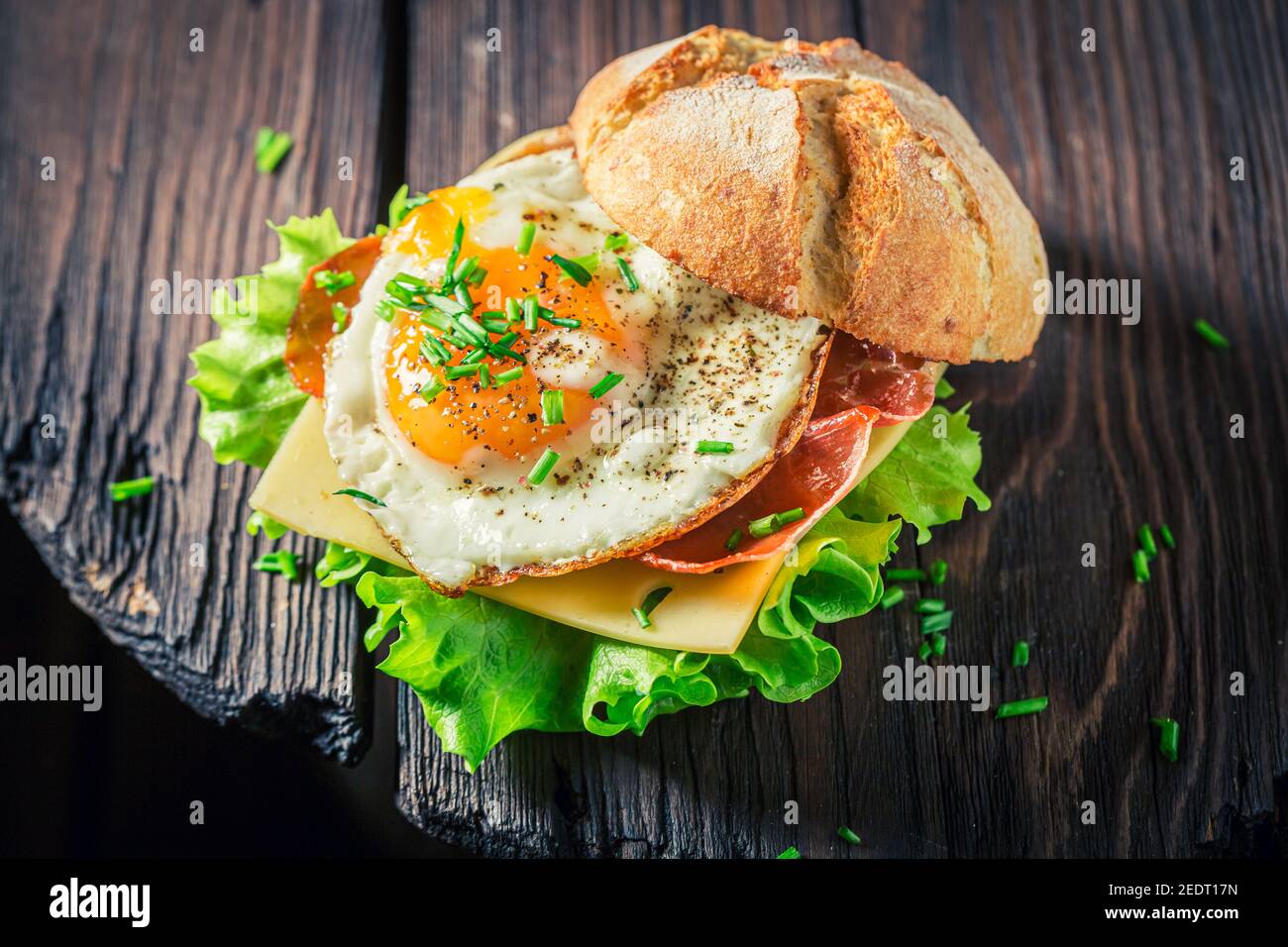 Delicious burger with lettuce, fried egg and bacon on white table Stock Photo