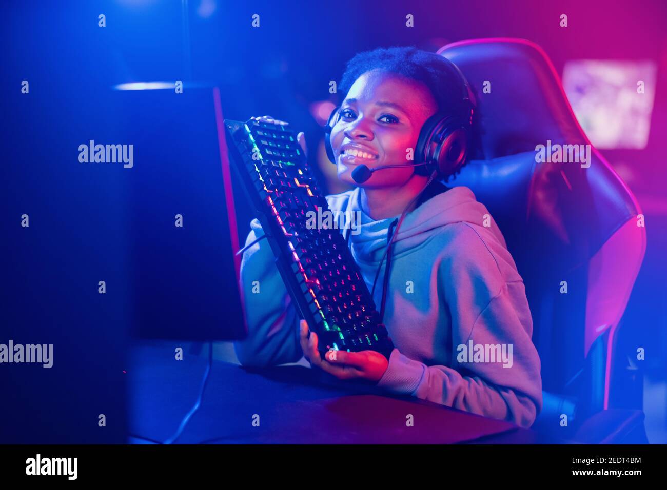 Happy webcam Streamer African woman play gamer playing online video games  computer neon color Stock Photo - Alamy