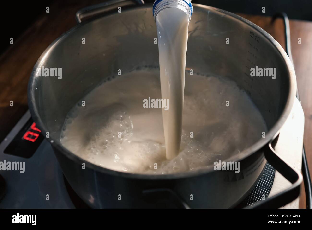 Pouring milk into the pan on the scales Stock Photo - Alamy