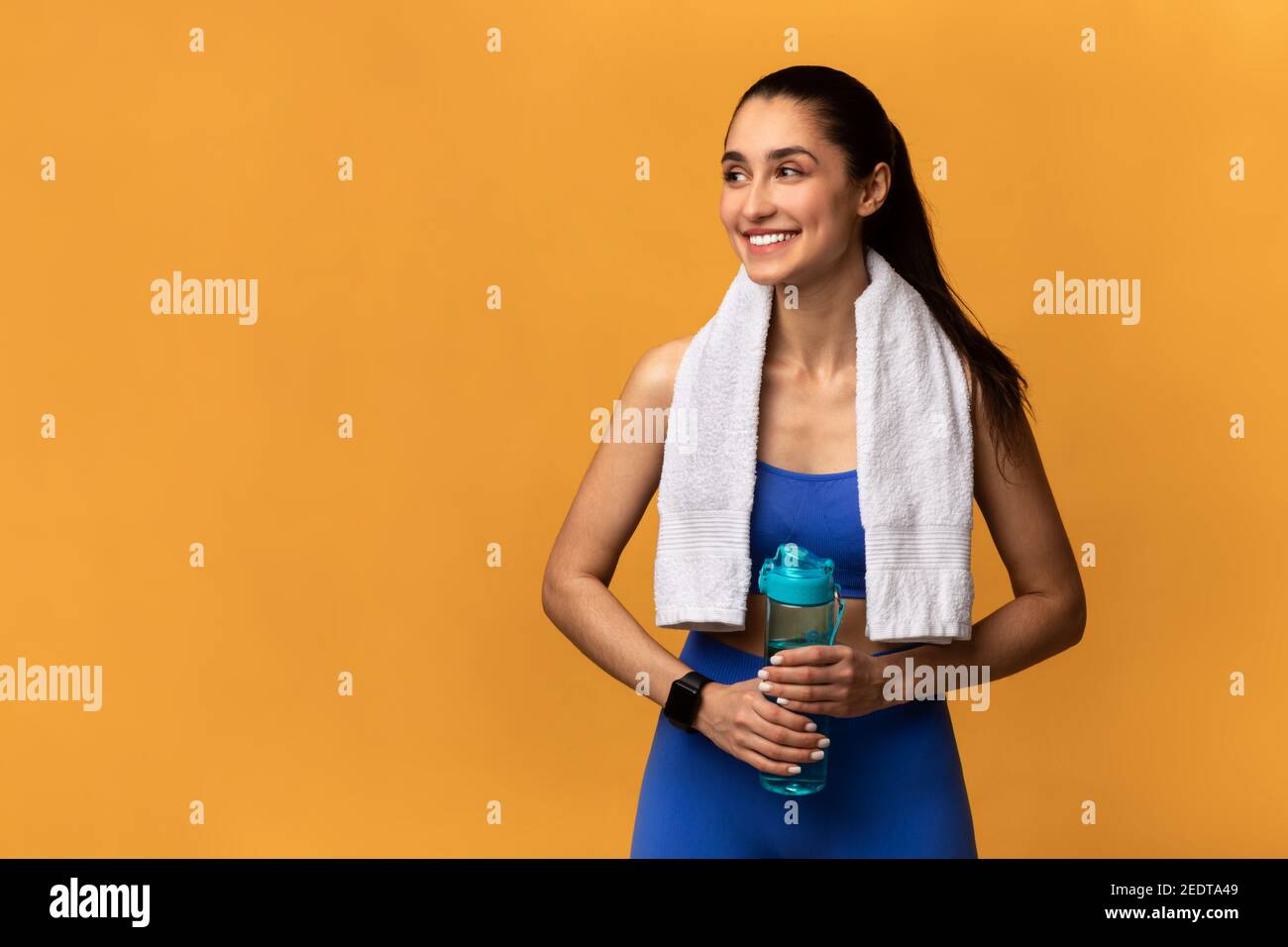 Sporty smiling woman standing with water bottle Stock Photo - Alamy