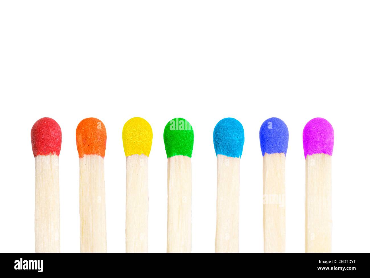 Vertical row of seven matches with match heads painted in rainbow colors isolated on white background. Stock Photo