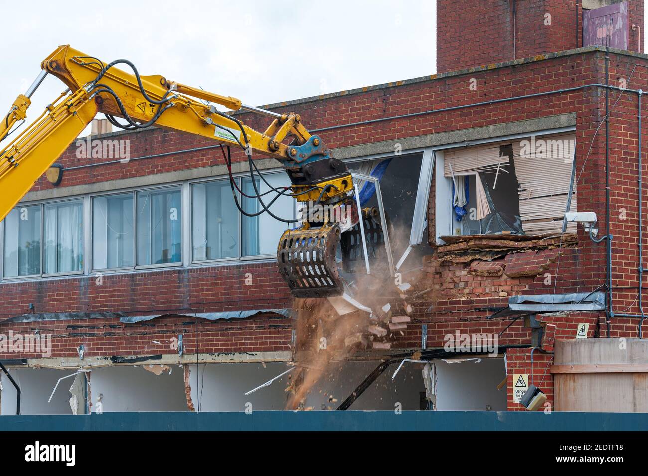 Demolition of an old building with a long reach machine hydraulic jaw. Regeneration of a space for new, modern building. Stock Photo
